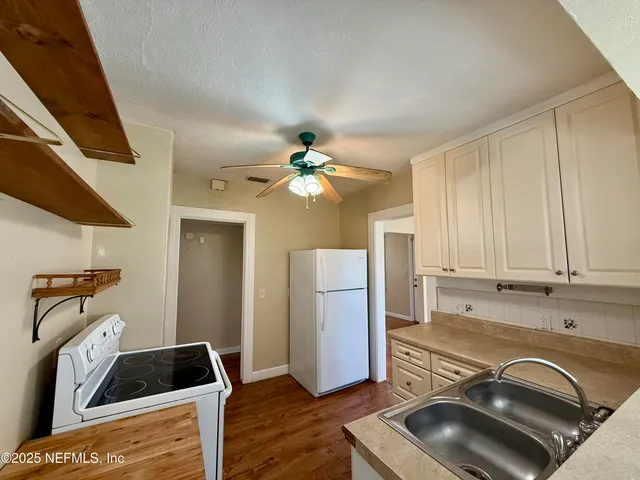 a kitchen with a refrigerator and a stove top oven