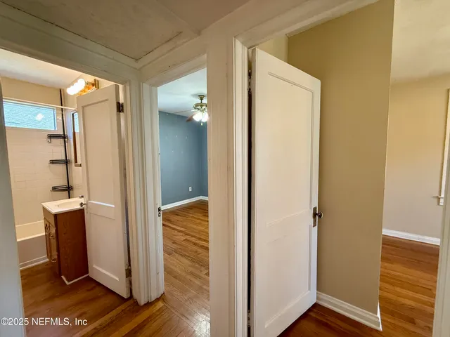 a view of a hallway with wooden floor and closet