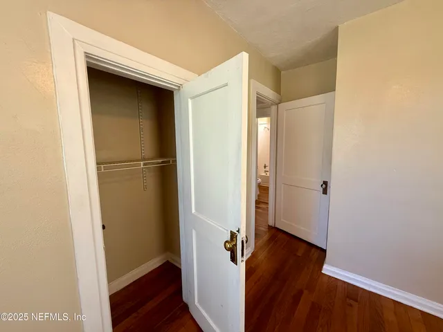a view of a hallway with wooden floor