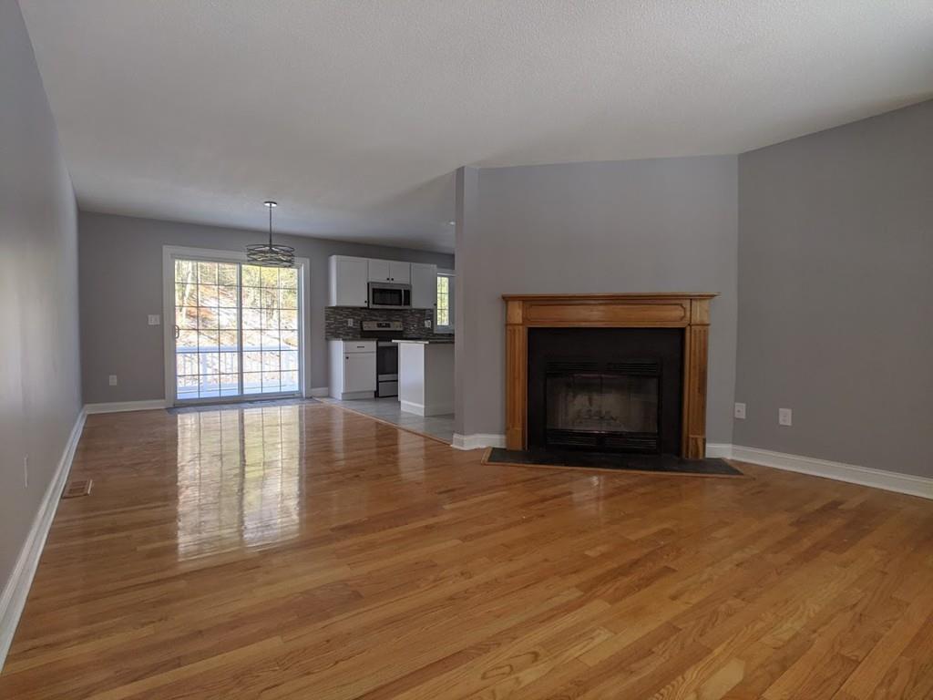 95 Babcock Tavern Road Ware, MA 01082 - Photo 9 of 31 a view of empty room with wooden floor and fireplace