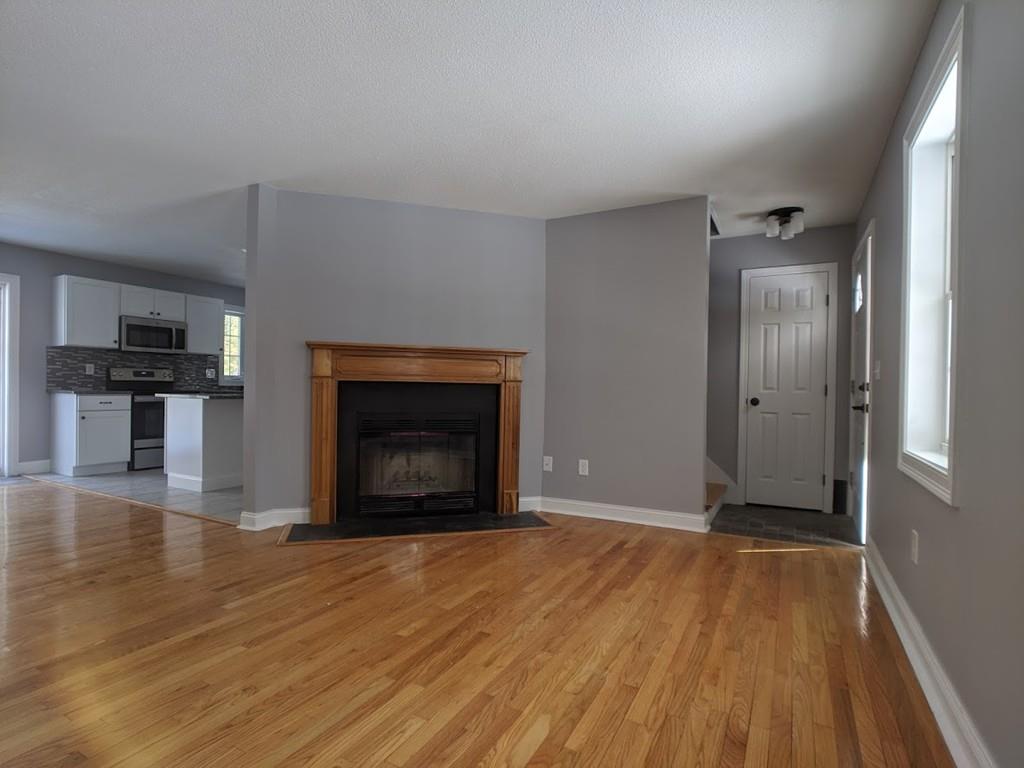 95 Babcock Tavern Road Ware, MA 01082 - Photo 10 of 31 a view of empty room with wooden floor and fireplace