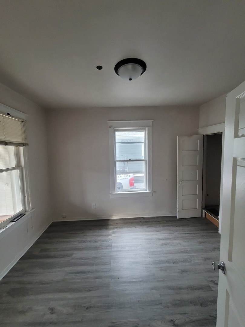 550 5th Avenue Aurora, IL 60505 - Photo 5 of 10 an empty room with wooden floor and windows