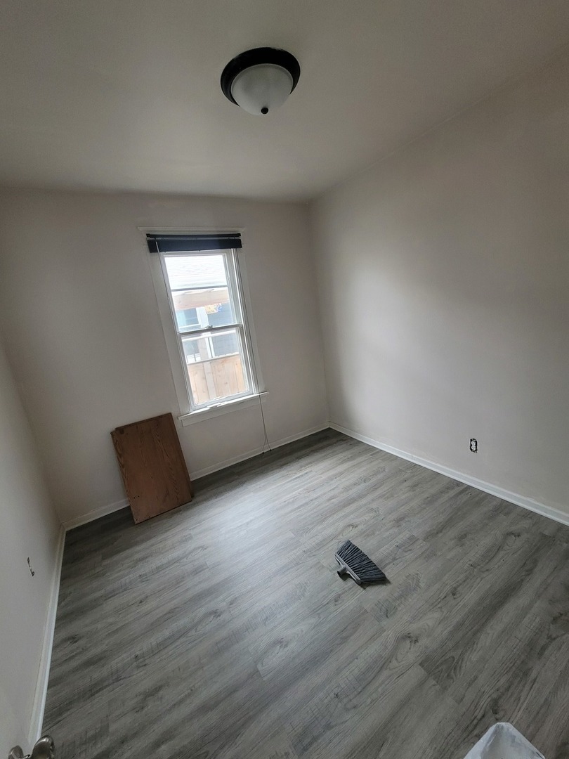 550 5th Avenue Aurora, IL 60505 - Photo 6 of 10 an empty room with wooden floor and windows