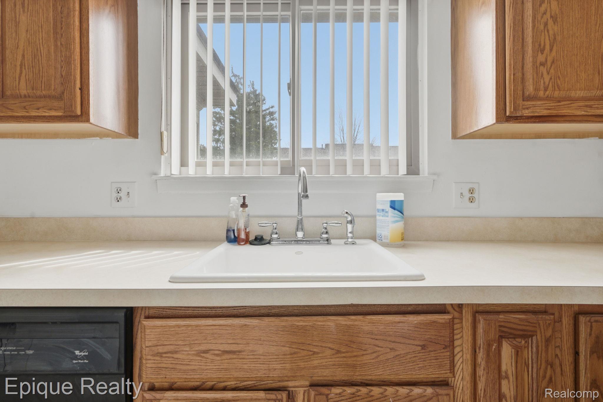 3895 Old Creek Road Troy, MI 48084 - Photo 12 of 23 Kitchen with wood finish cabinets, light countertops, and dishwasher