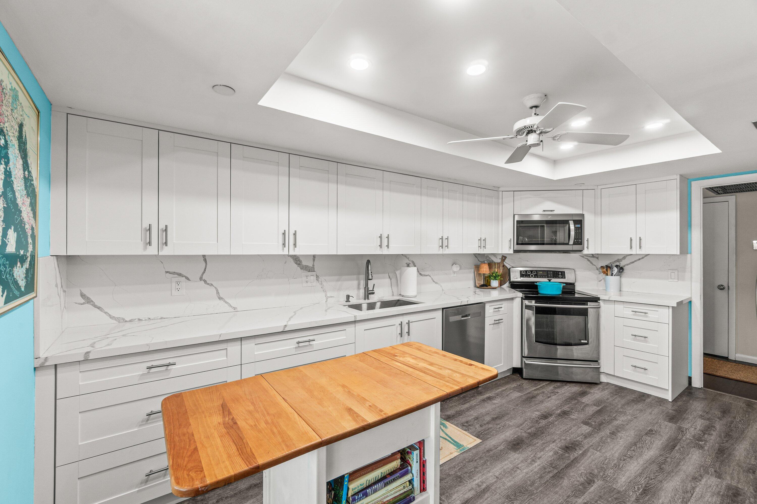 4301 North Ocean Boulevard, Unit 708 Boca Raton, FL 33431 - Photo 17 of 51 a kitchen with stainless steel appliances granite countertop a stove top oven a sink dishwasher and a refrigerator with wooden floor