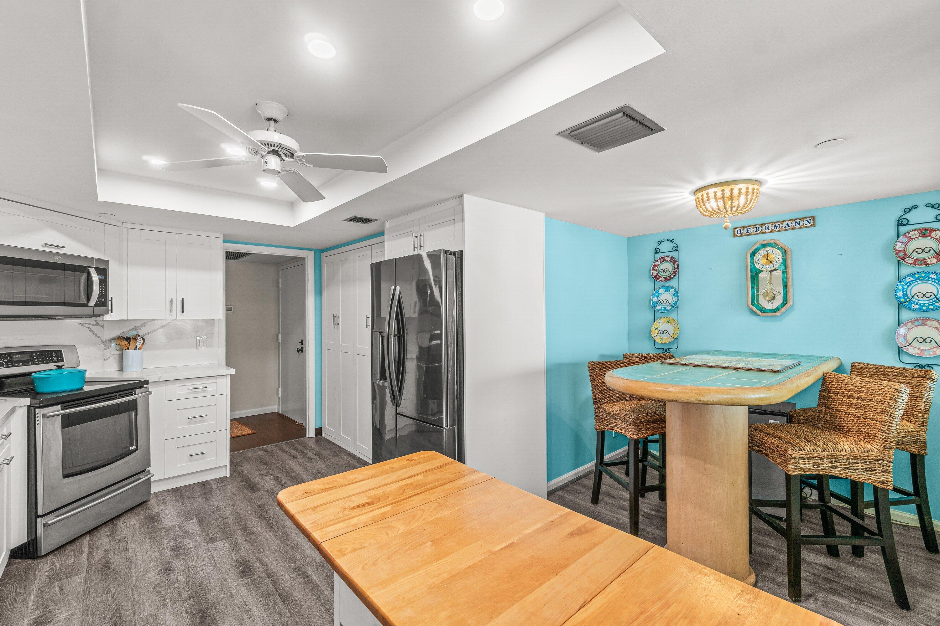 4301 North Ocean Boulevard, Unit 708 Boca Raton, FL 33431 - Photo 18 of 51 a kitchen with stainless steel appliances kitchen island a dining table and chairs