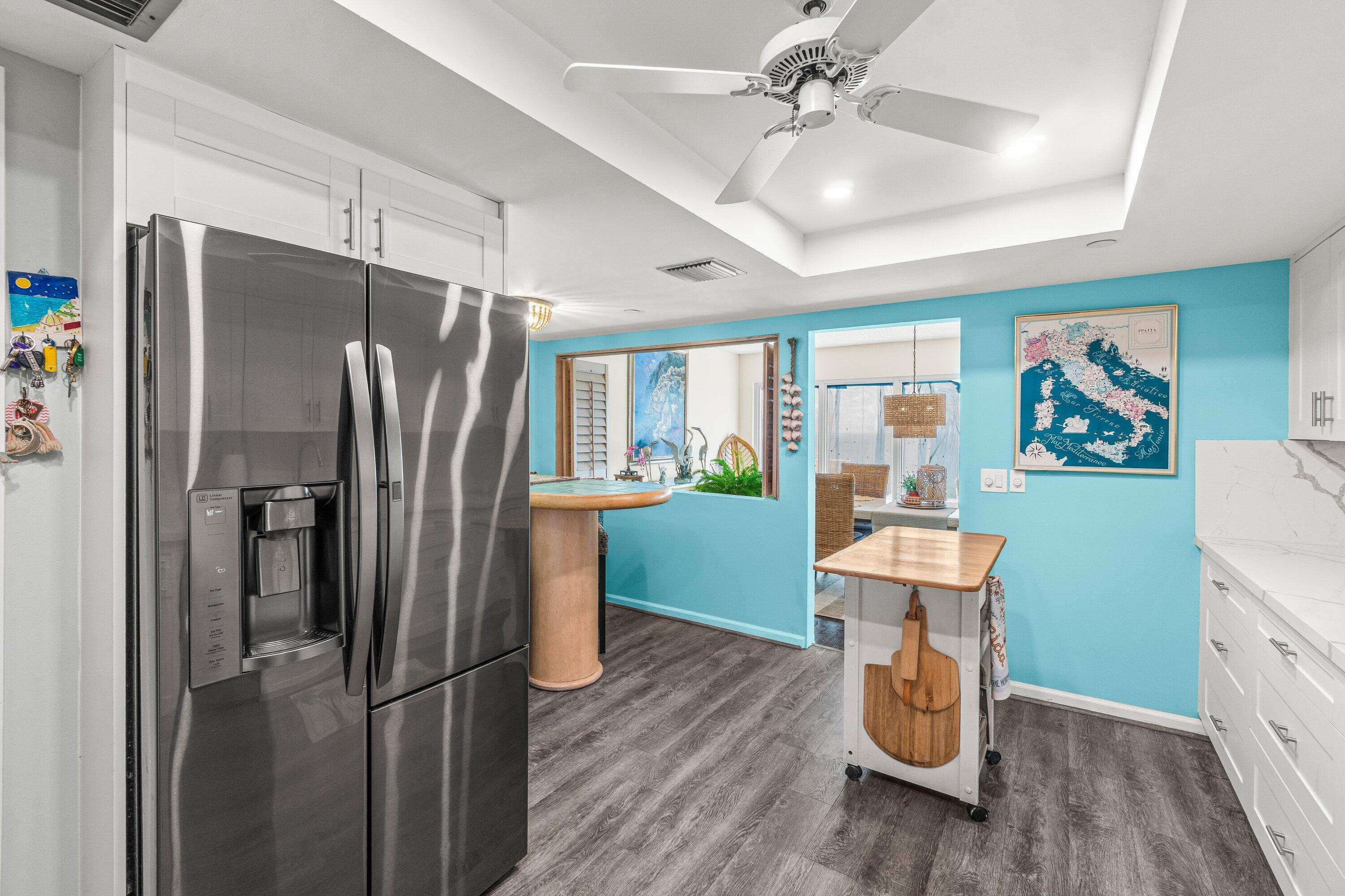 4301 North Ocean Boulevard, Unit 708 Boca Raton, FL 33431 - Photo 21 of 51 a kitchen with stainless steel appliances a dining table chairs refrigerator and sink
