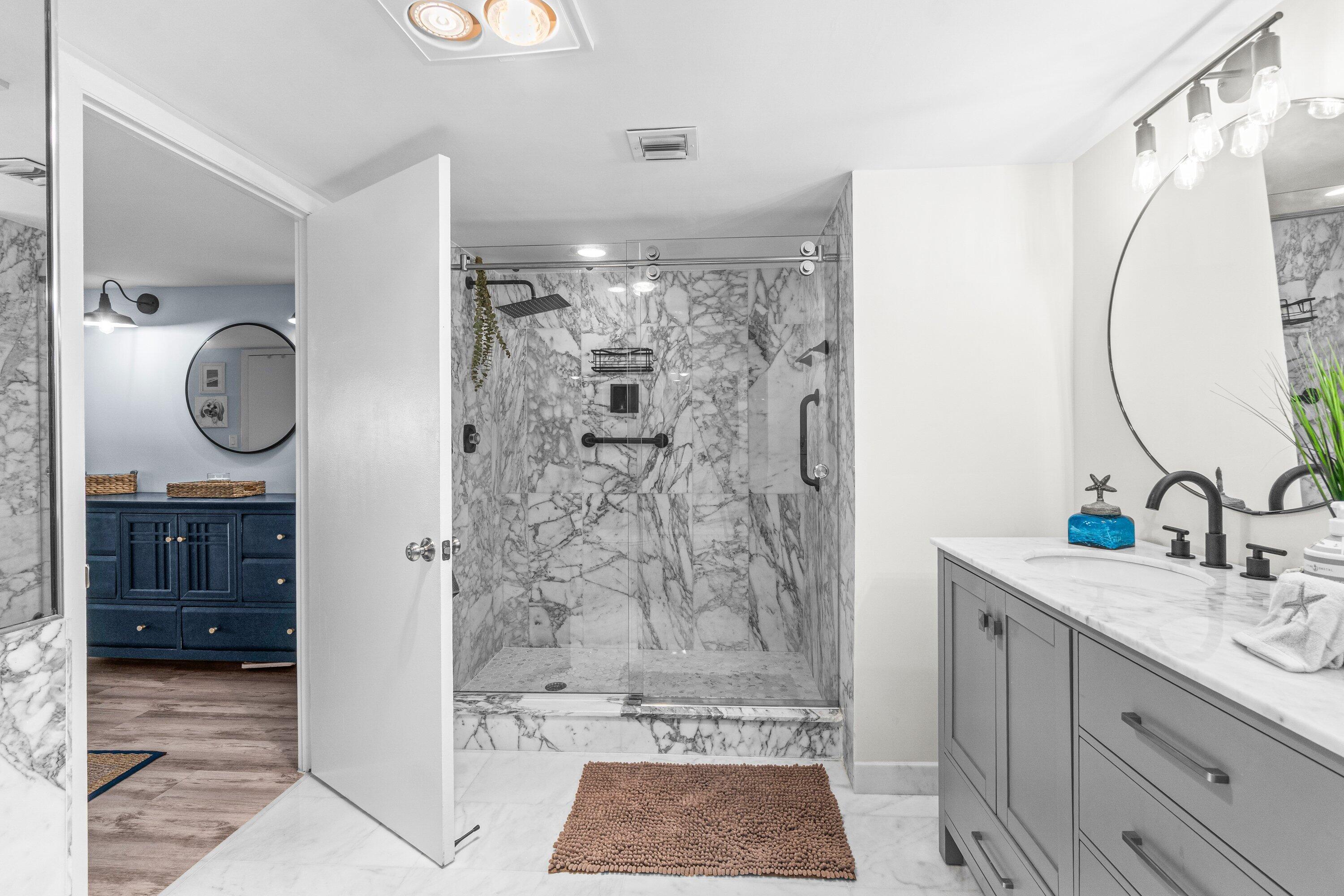 4301 North Ocean Boulevard, Unit 708 Boca Raton, FL 33431 - Photo 32 of 51 a bathroom with a sink a mirror a light fixture and a glass door shower