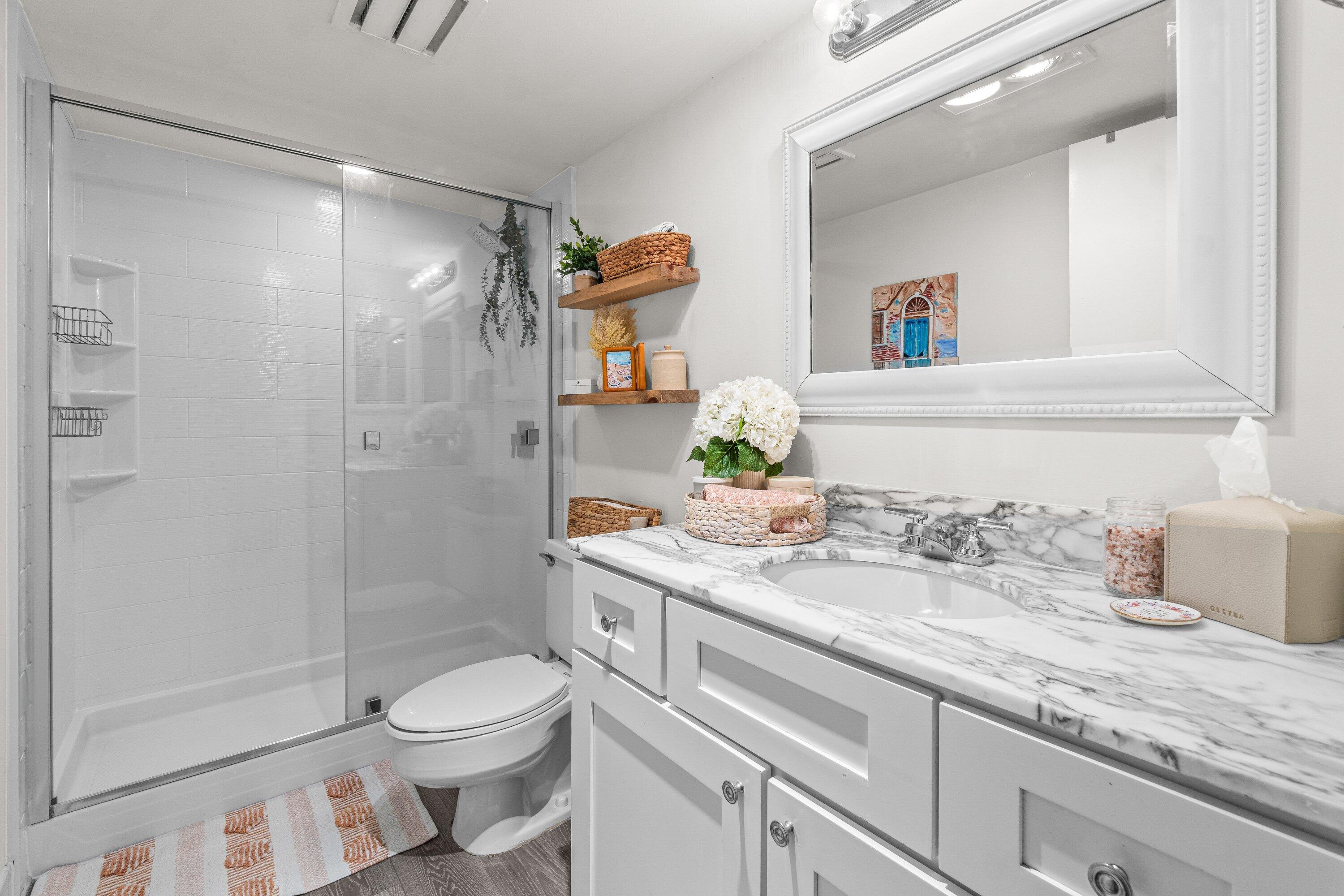 4301 North Ocean Boulevard, Unit 708 Boca Raton, FL 33431 - Photo 35 of 51 a bathroom with a granite countertop sink a toilet and shower