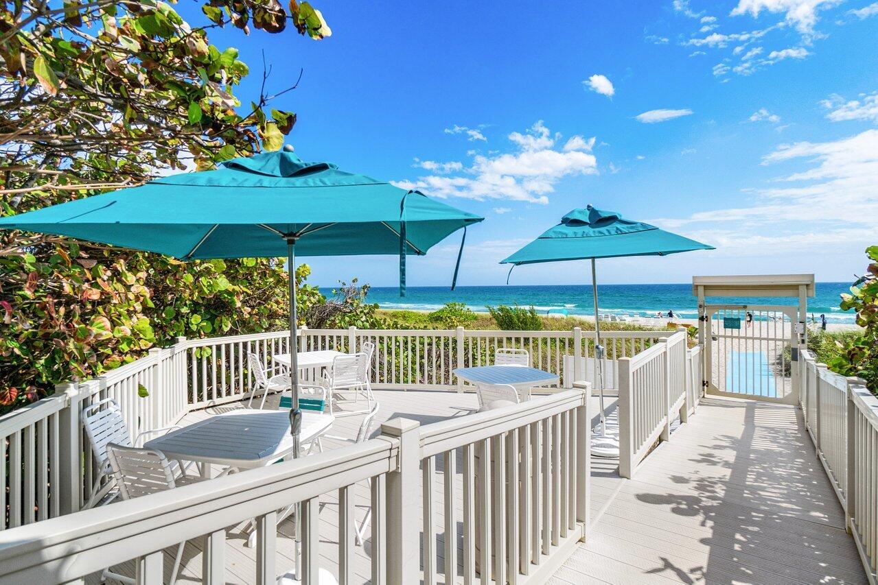 4301 North Ocean Boulevard, Unit 708 Boca Raton, FL 33431 - Photo 49 of 51 a balcony with furniture and umbrella