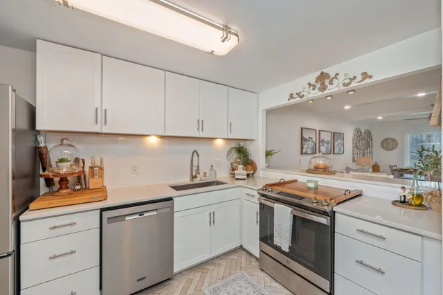 a kitchen with stainless steel appliances granite countertop a sink stove and cabinets