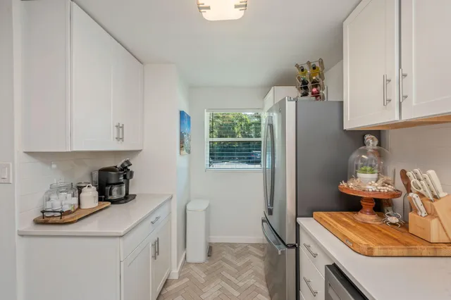 a kitchen with stainless steel appliances granite countertop a sink refrigerator and cabinets