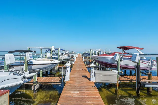 a roof deck with table and chairs under an umbrella with wooden floor