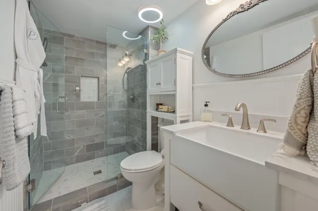 a bathroom with a sink a toilet and shower