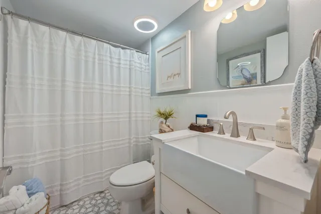 a bathroom with a sink a toilet and shower curtain