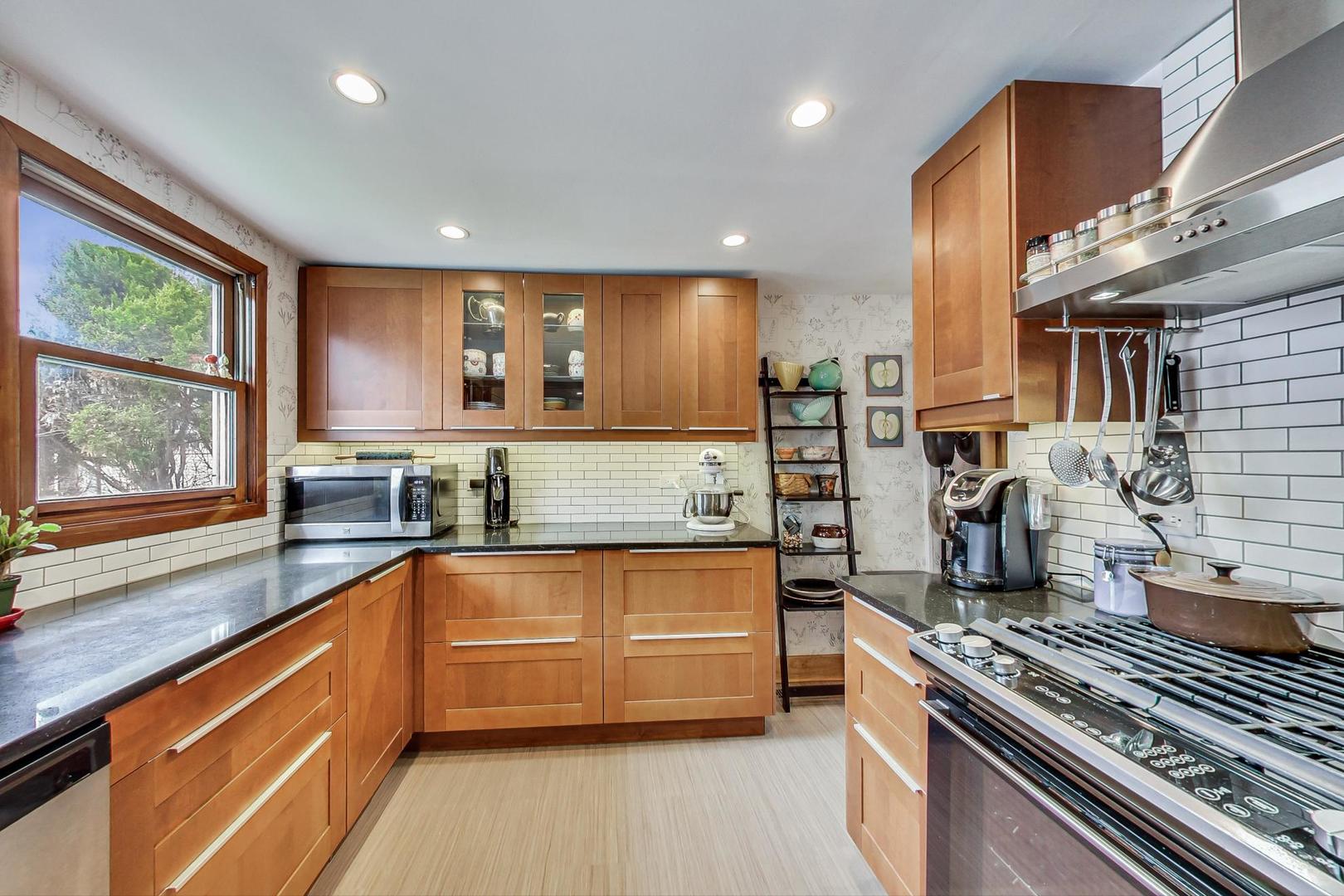 208 Waubansee Road Riverside, IL 60546 - Photo 14 of 38 a large kitchen with stainless steel appliances granite countertop a large stove a sink and dishwasher a oven with wooden cabinets