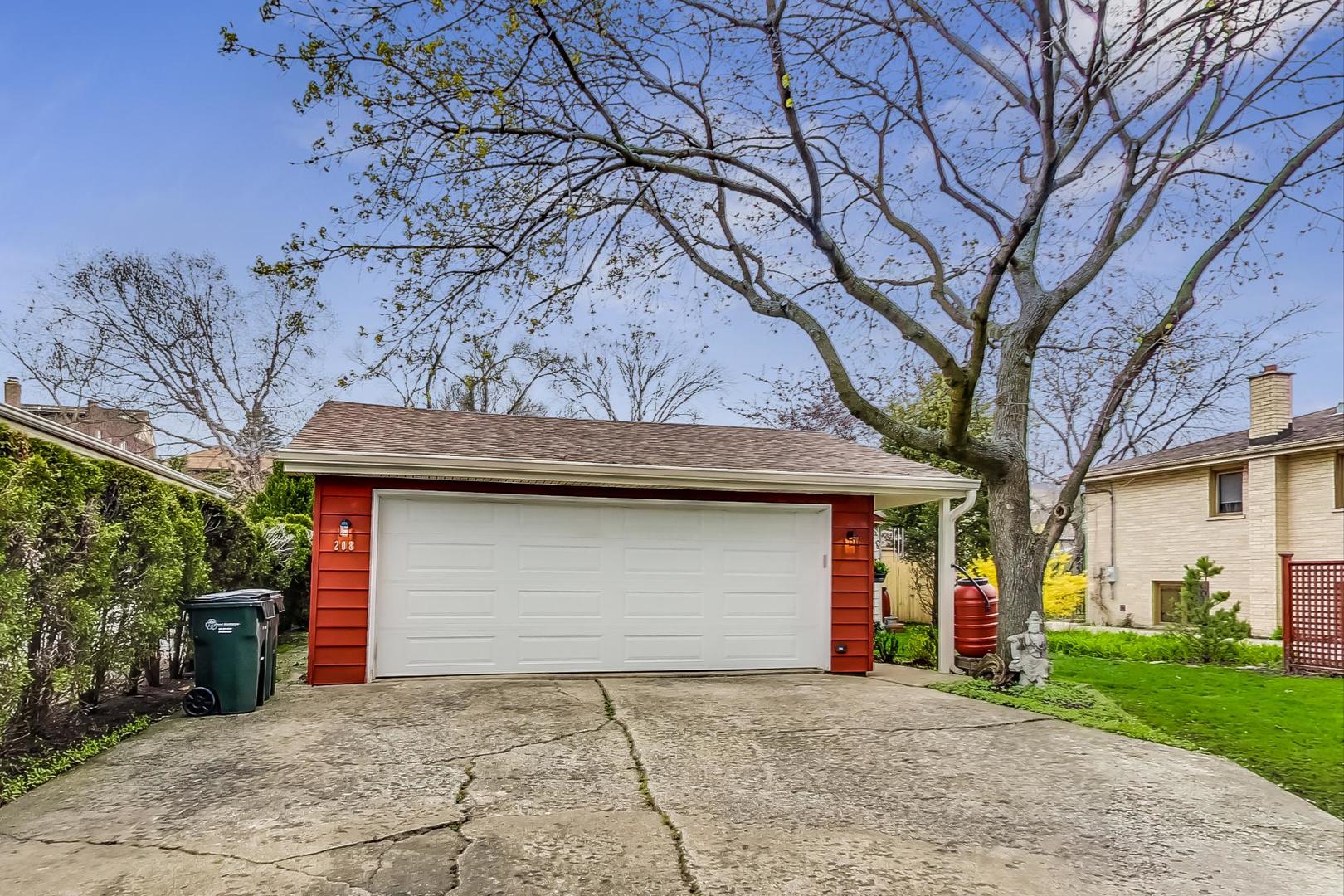 208 Waubansee Road Riverside, IL 60546 - Photo 36 of 38 a front view of a house with a yard and garage