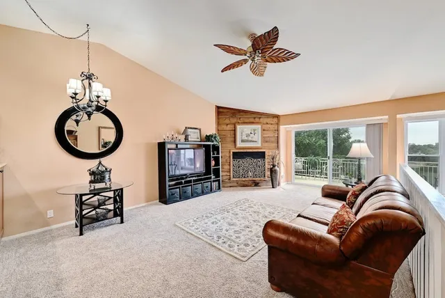 a living room with furniture a rug chandelier and a window