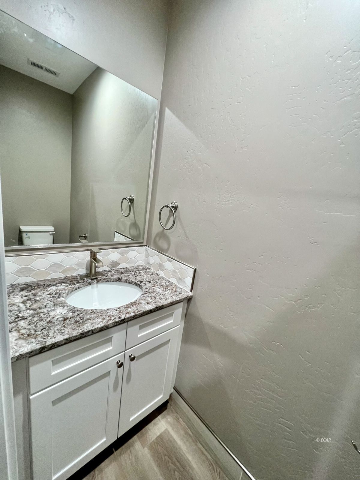457 Sun Vly Road Spring Creek, NV 89815 - Photo 22 of 33 a bathroom with a granite countertop sink and white cabinets