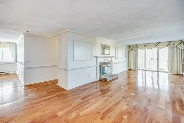 a view of empty room with wooden floor and window
