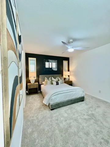 a bedroom with a large bed and a painting on the wall