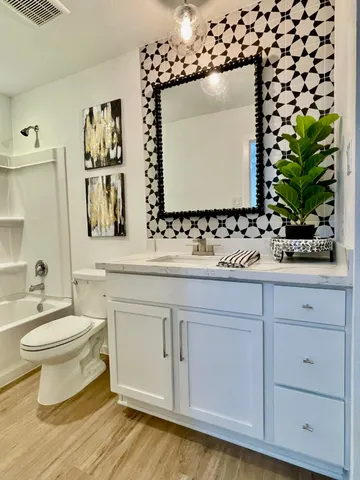 a bathroom with a sink vanity mirror and toilet