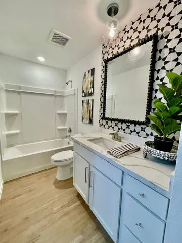 a spacious bathroom with a double vanity sink mirror and toilet