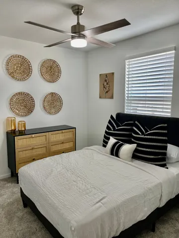 a bedroom with a bed and painting on the wall