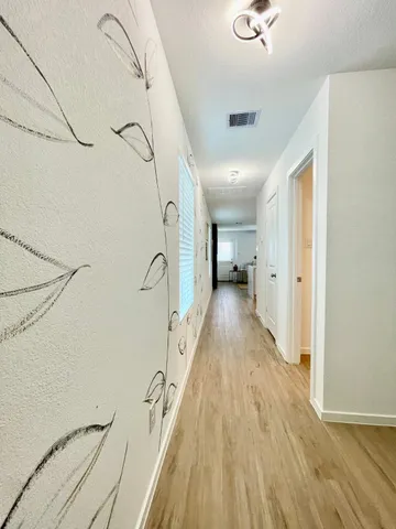 a view of a hallway with wooden floor and staircase