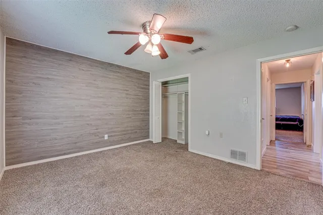 a view of an empty room with a chandelier fan