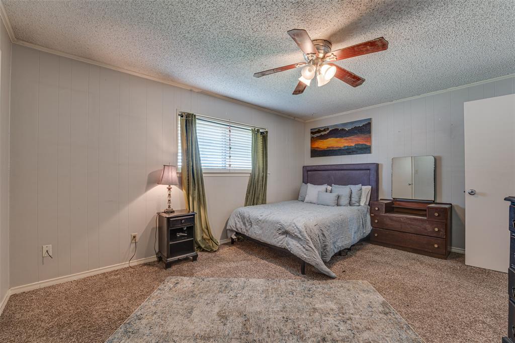 903 Walnut Street Royse City, TX 75189 - Photo 15 of 28 a bedroom with a large bed and a chandelier