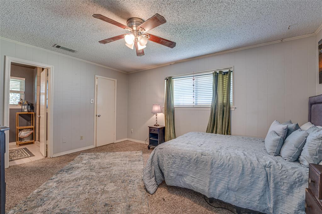 903 Walnut Street Royse City, TX 75189 - Photo 16 of 28 a bedroom with a large bed and a chandelier