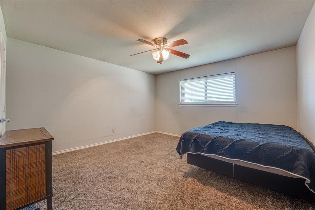 903 Walnut Street Royse City, TX 75189 - Photo 18 of 28 a bedroom with a bed and a chandelier