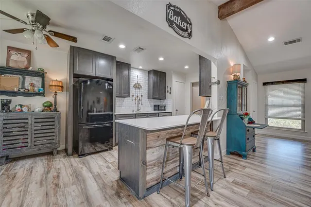 a kitchen with stainless steel appliances a refrigerator and a stove top oven