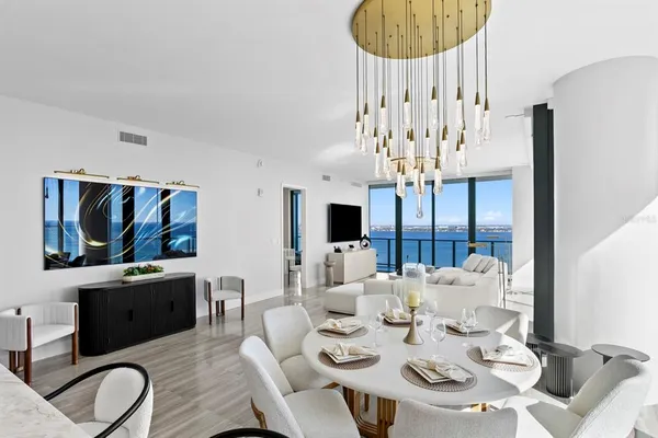 a large white kitchen with stainless steel appliances granite countertop a sink a stove and a refrigerator