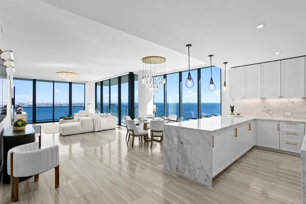 a large white room with a large window and furniture