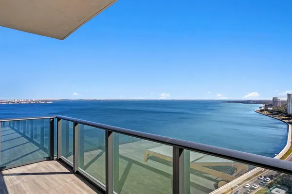 a view of a field with an ocean in the background