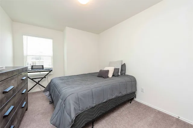 a bedroom with a bed and a couch next to a window