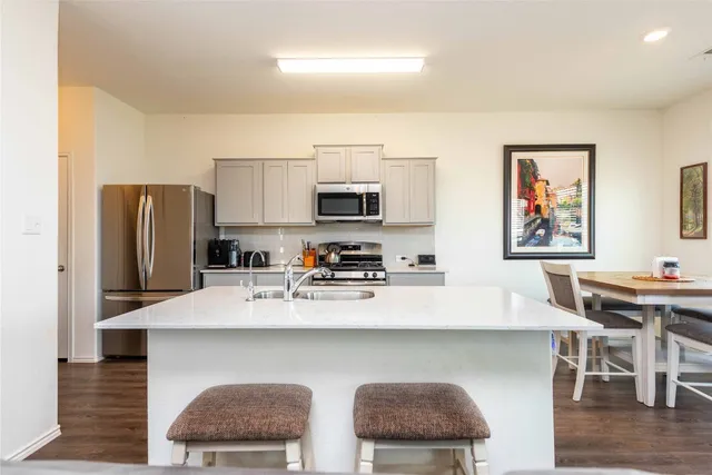 a living room with furniture kitchen view and a flat screen tv