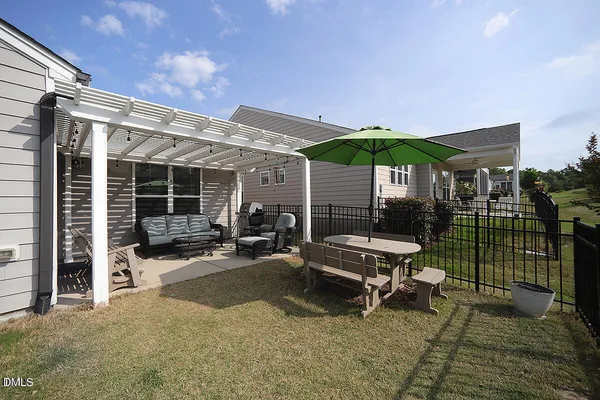 a view of a patio with a table and chairs under an umbrella