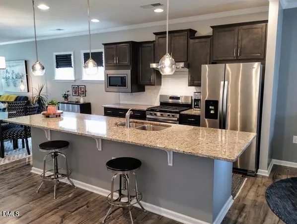 a kitchen with a refrigerator a sink and chairs
