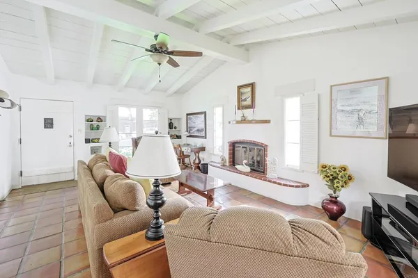 a living room with furniture a fireplace and a flat screen tv