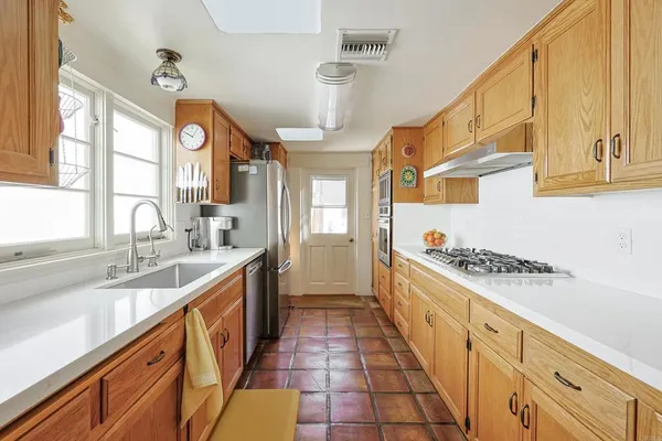 a kitchen with stainless steel appliances a sink stove and cabinets