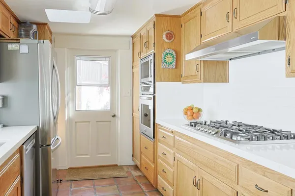 a kitchen with stainless steel appliances granite countertop a refrigerator a stove and a sink
