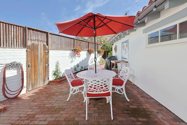 a view of a patio with table and chairs under an umbrella