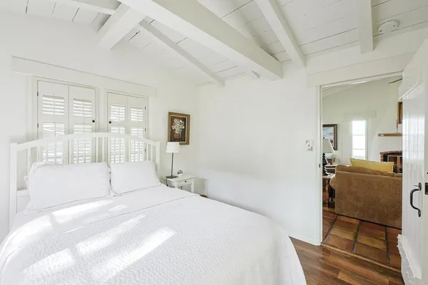 a bedroom with a bed and a large window with bathroom
