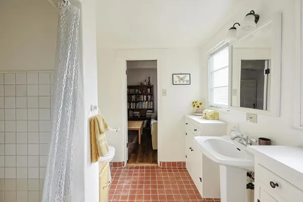 a bathroom with a sink a toilet and shower