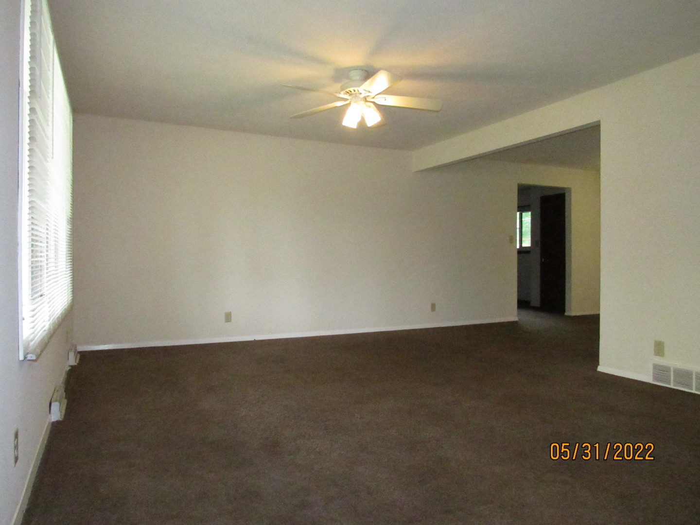 817 Normal Road DeKalb, IL 60115 - Photo 3 of 24 an empty room with a chandelier fan and windows