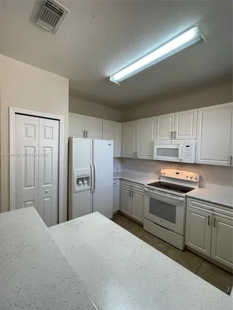 a kitchen with stainless steel appliances granite countertop a refrigerator and a stove top oven