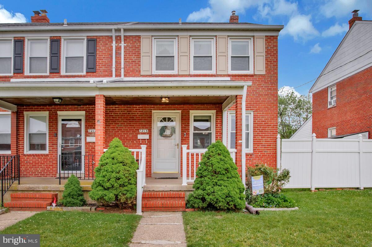a view of a brick building with a yard potted plants and a table